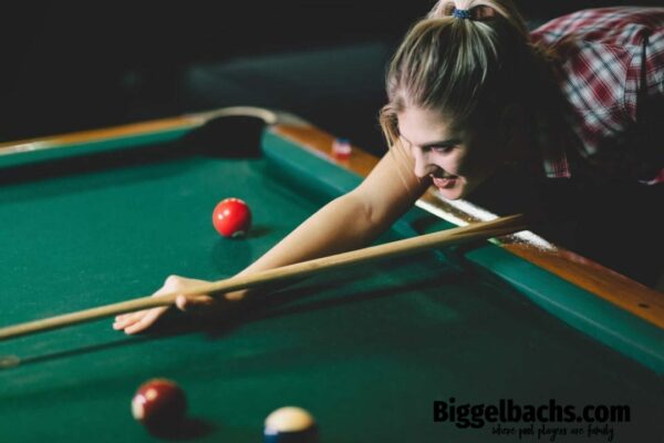 Young attractive woman playing pool in bar